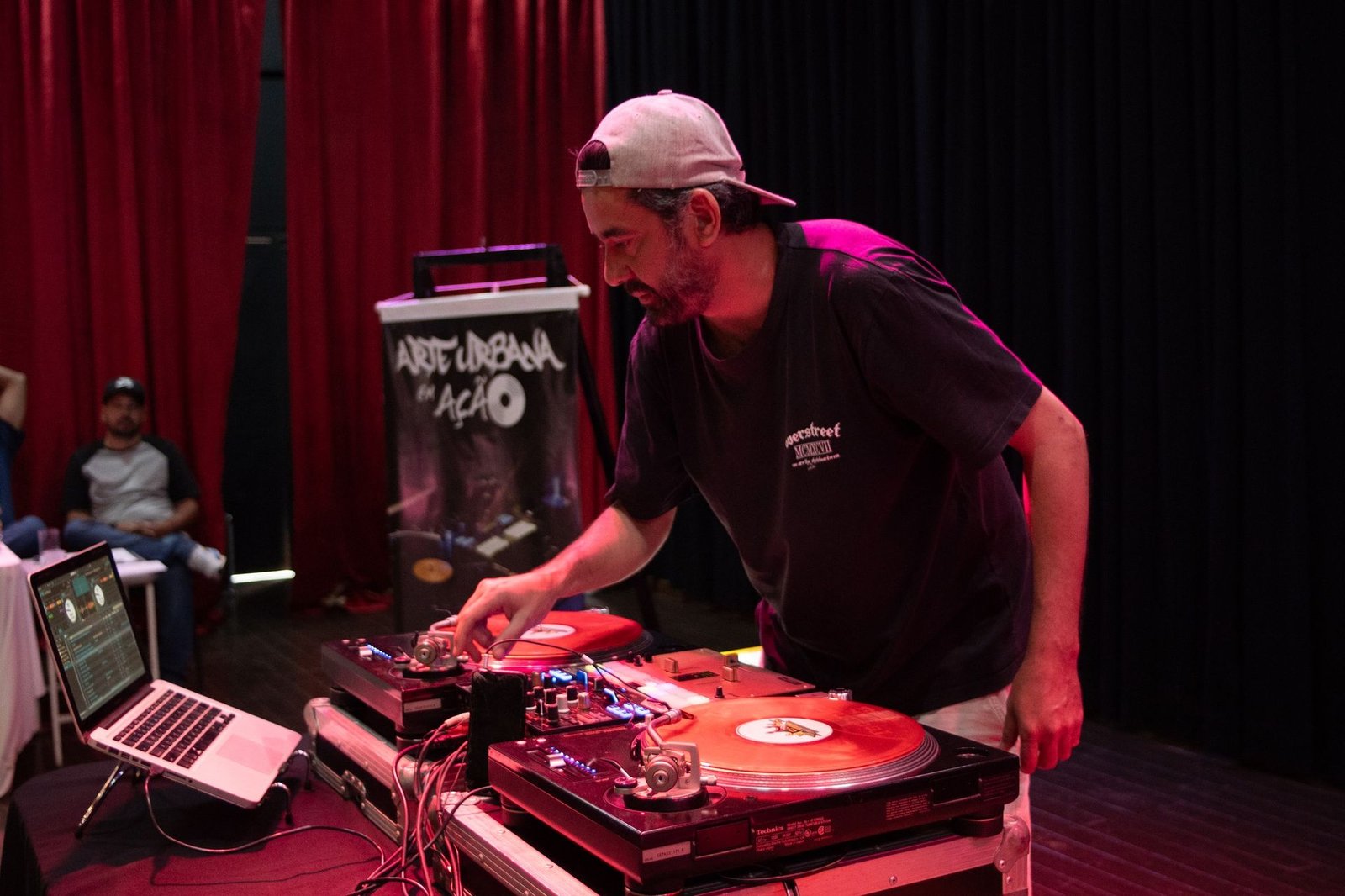 DJ YGO em set ao vivo no evento Arte Urbana em Ação, girando vinil